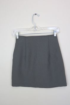 A simple Gray Green mini skirt from the 90's that is perfect for all seasons and a variety of style genres. It features darts along the waist for the fitted A-line shape, and zips up the back. The skirt is unlined, and the fabric feels like a lightweight polyester with no stretch to the material.  GARMENT MEASUREMENTS (in Inches) Waist: 24" Hip: 34" Hemline: 36" Length: 16.5" Estimated Best Fit: Size XSmall **all Measurements are taken with the garment lying flat, then doubled. Be sure to leave room for movement and comfort** CONDITION: VINTAGE GOOD: Good condition, some visible wear but no serious flaws to make note of. LABEL: O & E Odds and Evens,  MATERIALS: 100% Polyester SIZE LABEL: 3 *please note that vintage size labels vary wildly and refer to the size chart and garment measurement Style Genres, Gray Mini Skirt, 24 Inch Waist, Grey Mini Skirt, Green Mini Skirt, Short Skirt, Gray Green, Green And Grey, Fashion Blog