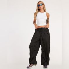 New Without Tags Color Black Size Medium In A Black Hue, These, Features A Low Rise Design With Fit And Tie Up Detailing. Trendy Black High Waist Parachute Pants, Baggy 90s Black Bottoms, 90s Style Black Baggy Bottoms, 90s Style Black Baggy Pants, 90s Style Baggy Black Bottoms, 90s Style Baggy Black Pants, Chic High Waist Parachute Pants For Streetwear, Black Urban Parachute Pants For Spring, Black Wide Leg Parachute Pants For Summer