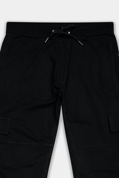 Indulge in comfort and style with our Jade Black Premium French Terry Cotton Cargo Joggers, perfect for sports and nighttime lounging. Crafted for versatility, these joggers feature two cargo pockets for added functionality. The sleek black hue exudes sophistication while offering ultimate comfort. Pair them with a matching black t-shirt for a coordinated look that effortlessly combines style and relaxation, making them essential for any laid-back occasion. Fabric: Premium French Terry Cotton. Double reinforced front, back and side seams. Durable broad waistband with Concealed Strings. Thoughtful Construction. Two Pockets. One with Zipper. Concealed button placket with a front opening. Ideal for loungewear and leisure wear. Half elastic, No Crumbling in Front. Cargo Joggers, Lounge Pants, Black T Shirt, Leisure Wear, Button Placket, Black Tshirt, French Terry, Lounge Wear, Sports