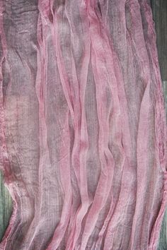 a piece of pink fabric sitting on top of a wooden table