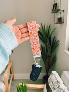 a person holding a cell phone in their hand with a flower pattern on the cover