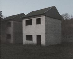 an old photo of a building in the middle of a field with no people around it