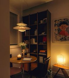 a room with a table, chair and bookshelf