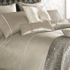 a bed with silver sequins and pillows on it