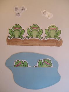 there are three stickers on the wall next to each other, and one has four green frogs