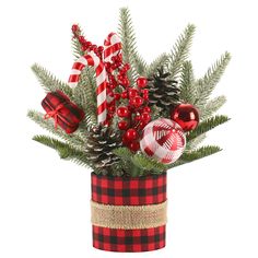 a christmas arrangement with pine cones, candy canes and ornaments in a plaid vase