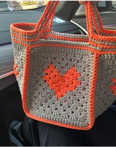 a crocheted bag is being held up in the car