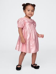 Soft rayon dress with allover metallic detailing Crewneck.  Short puff sleeves.  Bow applique at chest.  A-line silhouette with an easy fit.  Hits at the knee.  Sizes range from baby to toddler. Bow Applique, Bow Dress, Rayon Dress, Baby Gap, Toddler Dress, Toddler Gifts, Dress With Bow, New Woman, Puff Sleeves