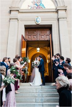 a bride and groom standing in front of a church door with confetti thrown around them