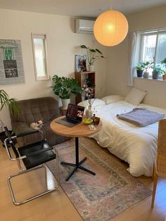 a small bedroom with a bed, desk and chair in front of a laptop computer