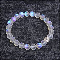 This Mermaid Bracelet Is Uniquely Designed With One Crystal Disco Ball Bead With A Sparkle That Will Surprise You. You Have To Experience One To Believe It! The Hypnotic Frosted White Moonstone Color Tells Tales Of Bringing Lovers Together. It Is The Color Of Choice For Weddings, Engagement, Anniversaries, Or As A Valentine's Day Gift To A Lover. This Stretchable Bracelet Is 7.5 Inches Round And Is Made To Fit Almost All Women's Wrists. Prepare To Be Swept Away By This Enchanted Bracelet That An White Moonstone Beaded Bracelet With 8mm Beads, White Crystal Bracelet With 8mm Beads, White Crystal Bracelet With Faceted Beads, White Faceted Beads Crystal Bracelet, Pearl White Crystal Bracelet With Round Beads, White Faceted Crystal Bracelet, White Beaded Moonstone Crystal Bracelet, White Crystal Bracelet With 8mm Round Beads, White Crystal Jewelry With 8mm Beads