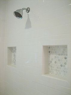 a white tiled shower with three niches on the wall