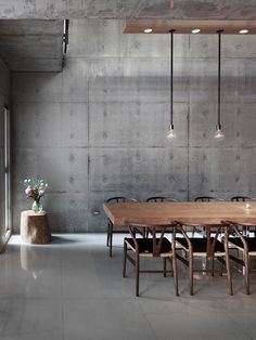 a table and chairs in a room with concrete walls