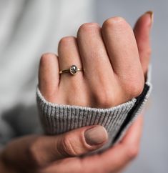 a woman's hand with a gold ring on her finger, showing the middle finger