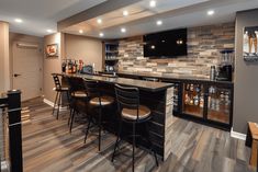 a home bar with several stools in front of it and a television on the wall