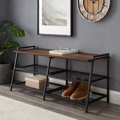 a pair of shoes sitting on top of a wooden table next to a clock and plant