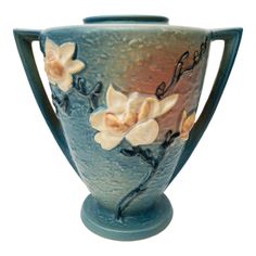 a blue vase with flowers painted on it