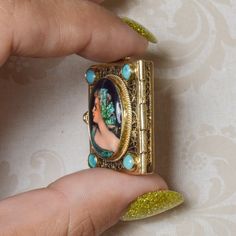 A vintage French handpainted locket; crafted in 14k yellow gold. This ornate locket is adorned with four round turquoise stones at each corner. Opens from the left side, inside of enamel picture is 'France' handwritten. This lady has a story and you were meant to be a part of hers. Previously loved, this estate locket is in excellent condition. Floating Diamond Ring, Unicorn Pendant, Estate Rings, Vintage Lockets, Turquoise Stones, Vintage French, Pure Silver, Turquoise Stone, French Vintage