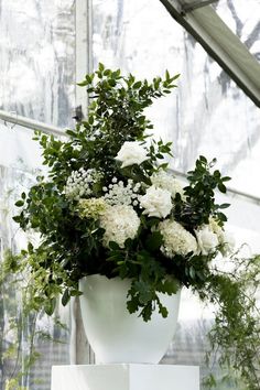 a white vase filled with flowers on top of a table