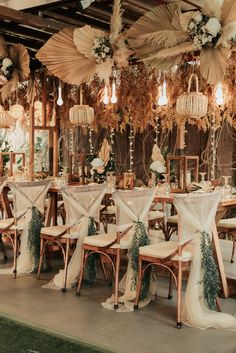 the tables are set up with white linens and greenery for an elegant wedding