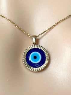 Sweet and lucky, this very pretty eye pendant/necklace is just the right amount of protection against all evil eyes or misfortune.  Beautifully handcrafted, simple, fashionable and elegant 14K solid gold. Eye is made of Murano Glass Beads, handcrafted, please expect some variation. You can wear the pendant back to back, one side with the eye, one side plain blue.  Made in Montréal Canada  Sold as pendant Only or with Chain. 💎Pendant Detail Metal Purity: 14K solid Gold Color: Yellow Gold Stamp: Spiritual Yellow Gold Necklace With Evil Eye, Yellow Gold Evil Eye Jewelry For Good Luck, 14k Gold Evil Eye Amulet Jewelry, Symbolic Round Evil Eye Jewelry, Spiritual Round Jewelry With Evil Eye Detail, Handmade 14k Gold Amulet Necklace, Spiritual Round Evil Eye Jewelry, Handmade Round Good Luck Jewelry, Evil Eye Round Jewelry Gift