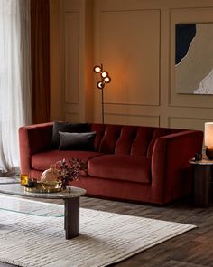 a living room with a red couch and coffee table