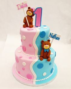 a two tiered birthday cake decorated with teddy bears and the number one on top