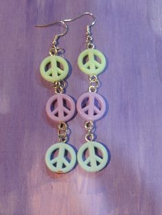 Give these peace signs a chance!! made during our crafts and a cocktail show on tiktok we turned these beads, into charms and then into earrings!! these super cute peace signs feature three beads, in green,purple and blue!  attached to a .925 silver dangle fish hook these earring are not only adorable but a best seller sure to move fast!! ships in a gift bag Makes a great Gift! Handmade Pastel Dangle Earrings, Trendy Handmade Pastel Earrings, Peace Signs, Fish Hook Earrings, Wedding Jewelry Earrings, Pastel Rainbow, Peace Sign, Fish Hook, Purple Green