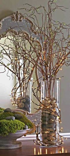 a vase filled with branches and rocks on top of a table