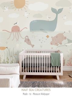 a baby's room with an ocean theme wallpaper and a crib in the foreground