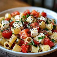 a white bowl filled with pasta and tomatoes