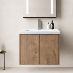 a bathroom with a sink, mirror and stool next to the wall in front of it