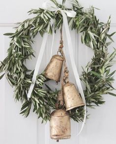 two bells hanging from a wreath on a door