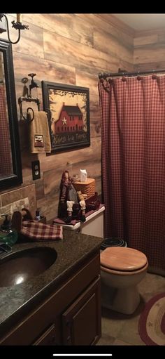 a bathroom with a toilet, sink and shower curtain in it's center area