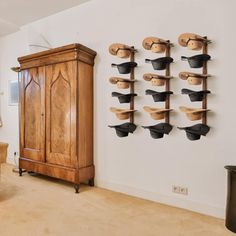 a living room filled with furniture next to a wooden cabinet and wall mounted coat rack