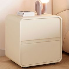 a white table with a light on top of it next to a chair and lamp