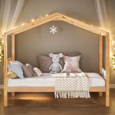 a bed with pillows and blankets on top of it in a room decorated for christmas