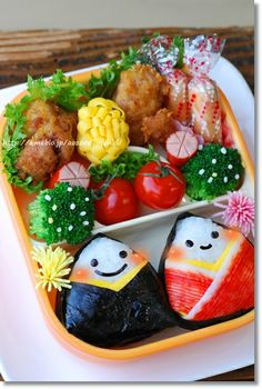 a tray with sushi and vegetables on it