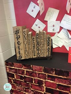 several books are stacked on top of a brick wall with sticky notes attached to them