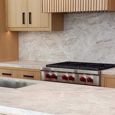 a stove top oven sitting inside of a kitchen next to wooden cabinets and counter tops