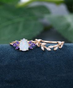 an opal, amethyst and diamond ring sits on a blue velvet surface