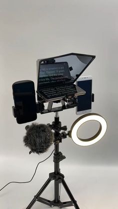 a camera on a tripod with a microphone in front of it and a laptop