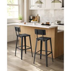 two black bar stools sitting in front of a kitchen island