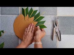 someone is cutting up some green leaves with scissors