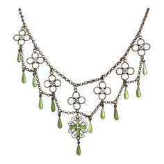 This antique silver and green and white enamel necklace was hand crated in the Arts and Crafts era, around 1910 by famed Norwegian silver smith Marius Hammer. Hammer lived from 1847-1927 and worked in Bergen, Norway. This drop necklace features flowers and drops of bright spring green and matte what enamel with that velvety look that Hammer was a master of. Chains of silver weave throughout this necklace, piecing together a lovely statement piece of swirls, loops, and twists. This piece weighs 10.3 grams and measures 16 inches in length. It has been acid tested. A mark on the back reads, ‘930S’, indicating fine silver and it bears the hallmark of the M with a hammer forming the center.  Wearable on a Saturday night date, give-able for a wedding present, presentable at a cocktail party, and Arts And Crafts Era, Festoon Necklace, Enamel Necklaces, Bright Spring, Green Enamel, Silver Enamel, Silver Chain Necklace, Drop Necklace, Metal Necklaces