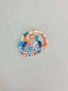 This ocean bracelet set is super cute and colorful! It's a great accessory or gift! Multicolor Beaded Bracelets For Beach Season Gift, Colorful Beaded Bracelets For Gifts - Beachy Style, Fun Vacation Jewelry With Letter Beads, Multicolor Stackable Friendship Bracelets For Beach, Fun Letter Beads Jewelry For Vacation, Multicolor Stackable Jewelry For The Beach, Multicolor Stackable Beach Jewelry, Beachy Beaded Bracelets As Gift, Beachy Beaded Bracelets For Gifts