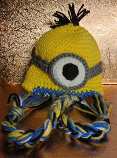 a crocheted yellow and blue hat with an eye