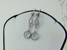 "Round set AAA quality natural rainbow moonstone gemstones highlight these elegant dangle earrings. The 8mm moonstones are suspended from antique oxidized silver scroll connectors. These dazzling moonstones are set in silver JBB crown bezels. Oxidized silver earwires have a filigreed ball. These earrings measure 1 3/4\" in overall length. The iridescent round rainbow moonstone are set in a sterling crown bezel. These earrings have a rainbow sparkling appearance. These lovely earrings would make Elegant Hypoallergenic Moon-shaped Jewelry, Elegant Hypoallergenic Moon Shaped Jewelry, Moonstone Crystal Dangle Earrings, Nickel-free Moonstone Moon-shaped Earrings, Nickel-free Moonstone Moon Earrings, Elegant Adjustable Moon Shaped Earrings, Elegant Hypoallergenic Moon Shaped Earrings, Hypoallergenic Silver Moonstone Jewelry, Nickel-free Moonstone Dangle Jewelry