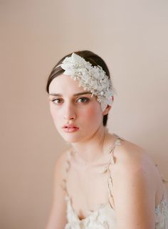 a woman wearing a white flower head piece