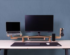 two computer monitors sitting on top of a desk next to a keyboard and mouse pad